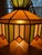 Vintage hanging light featuring rich green, gold, amber and ivory panels with decorative metal trim. A true mid century...