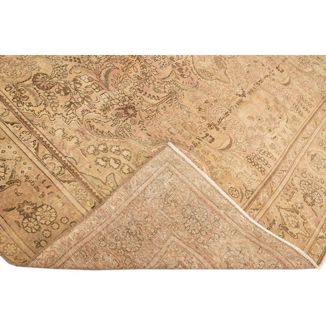 Beautiful Vintage Persian distressed hand-knotted wool rug with a beige color field. This piece has brown accents in an...