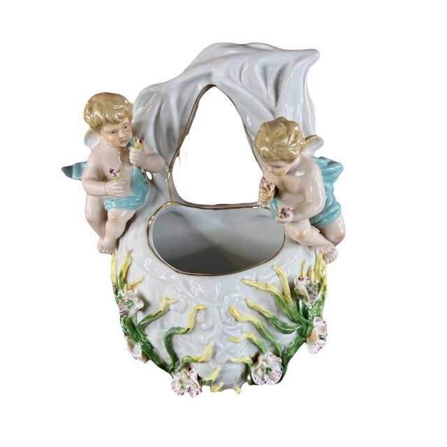 This magnificent wall decoration piece has a mesen porcelain or bouquetière vase. Two charming cherubs hold bouquets of...