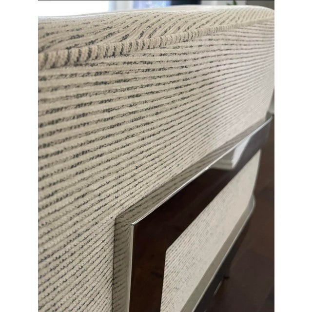 Pair of Mitchell Gold + Bob Williams lounge chairs featuring a curved barrel silhouette, textured neutral upholstery, and...