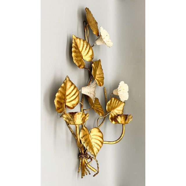 Lovely pair of mid-century Italian gilt tole wall sconces. Each sconce holds two taper candles. These two-arm sconces...