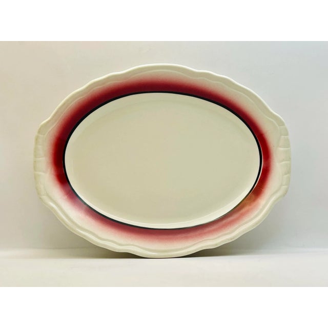 A simple platter with a raised decoration around the edges and a band of color radiating outwards.