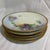 This vintage porcelain plate features a hand-painted purple violet floral design with a gold trim rim, characteristic of...