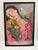 Lush vibrant colorful framed print of a woman resting amidst flowers with a whimsical parrot on her shoulder. Pinks and...