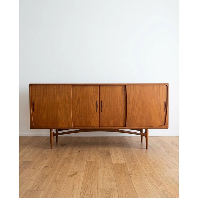 Danish sideboard from the 1950s in teak, approximately 200 cm. Four sliding doors with double vertical handles. The base...