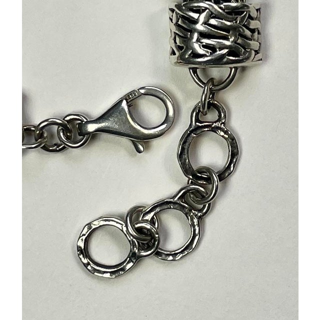 This beautiful bracelet is made up of eleven chains of varying link styles and a slider charm that matches the end caps....