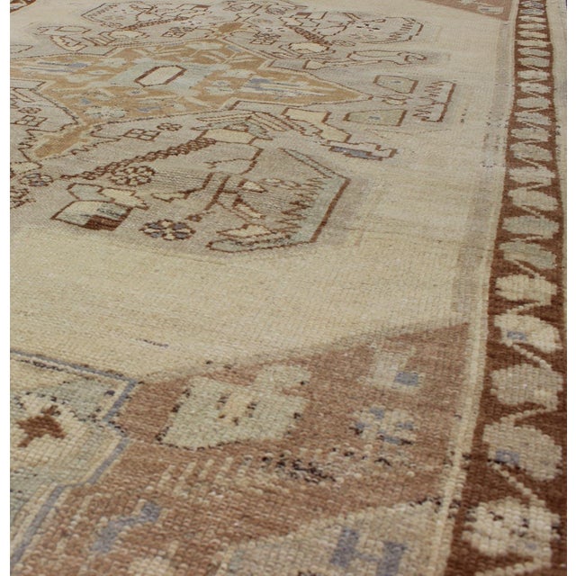 This Turkish Vintage Oushak contains subtle tones of taupe, beige and gray-blue, which are highlighted by brown and mocha...