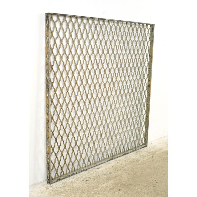Industrial style tan and gray painted steel security panel made of woven wire in a diamond pattern with a rectangular...