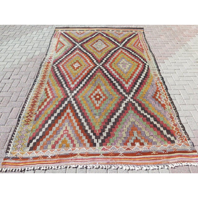This beautiful, traditional vintage, flatweaved Turkish kilim rug is approximately 60 years old. It is handmade of very...