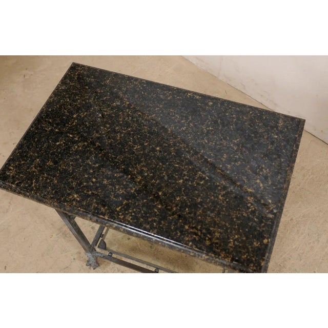 An American bronze table with acanthus leaf motif, granite top, and lower shelf, circa 1920's. This antique rectangular-...