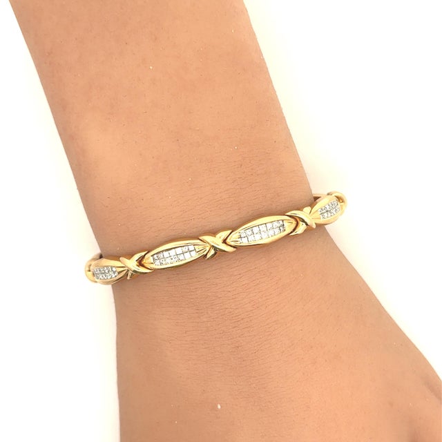 A contemporary link bracelet crafted in 14k yellow gold. The design features princess white diamonds, totaling 3.00...
