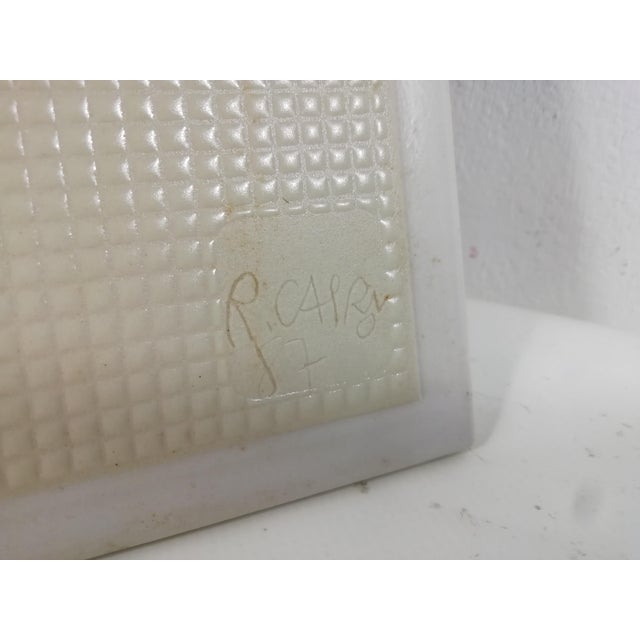 Tile manufactured by Marazzi ceramics, hand-decorated and signed by Roger Capron '87. It depicts a blue-colored sun that...