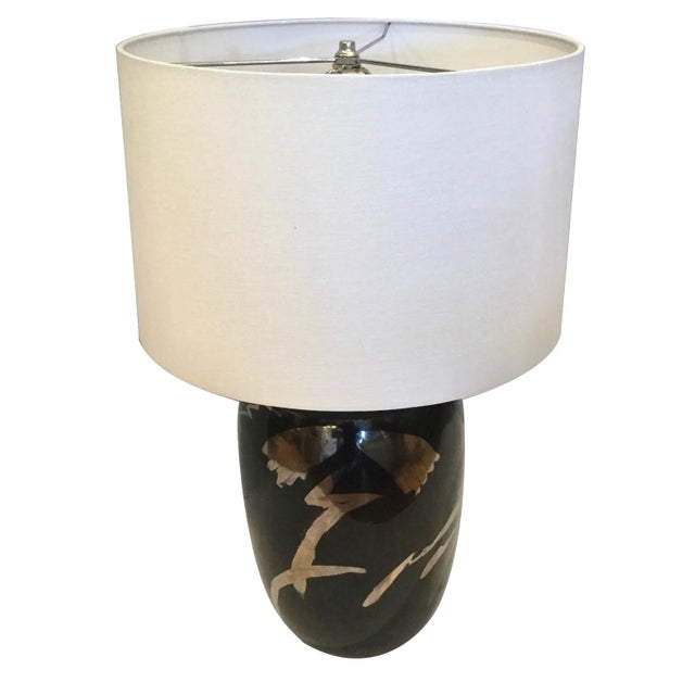 This vintage black ceramic lamp with hand-painted silver detail and has a new white drum shade. This lamp is in beautiful...