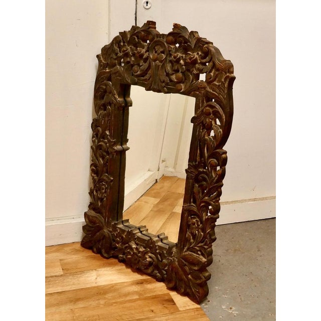 Heavily carved fruitwood mirror. A lovely piece from the east the 6” wide frame is intricately carved with leaves and...