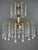Elegant two-tiered chandelier in gilded brass, richly adorned with teardrop-shaped glass pendants. Its airy structure,...