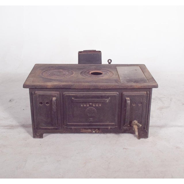 This robust Portuguese wood-burning stove, made entirely of cast iron, is a fine example of mid-20th century domestic...