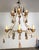 French Provincial style two-tier wrought iron chandelier adorned with gilt tassels. The hand forged frame features an...