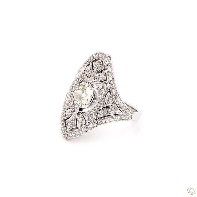 This estate ring, an early-twentieth-century antique design, centers on a 0.87-carat diamond in an old European cut, an...