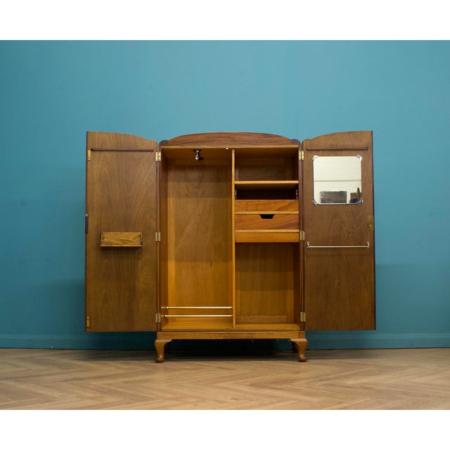 A 1930s walnut compactum wardrobe with beautifully figured veneers, an arched top and original cabriole feet. Compact yet...