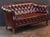 A handsome Swedish sofa or settee of tufted oxblood leather in the Chesterfield style, featuring a gently arching...