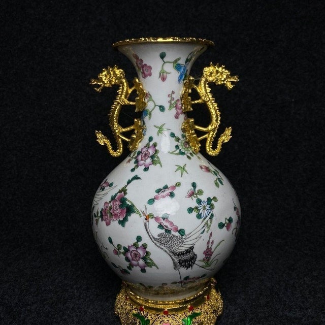 This is an ornate vintage Chinese porcelain vase, featuring a white ground decorated with vibrant famille rose enamel...