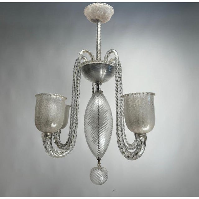 An elegant five-arm chandelier by Ercole Barovier, crafted from Murano glass using the signature silvered and iridescent...