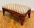This charming vintage footstool has gently curved wood legs and has been newly upholstered in a mid-century jacquard...