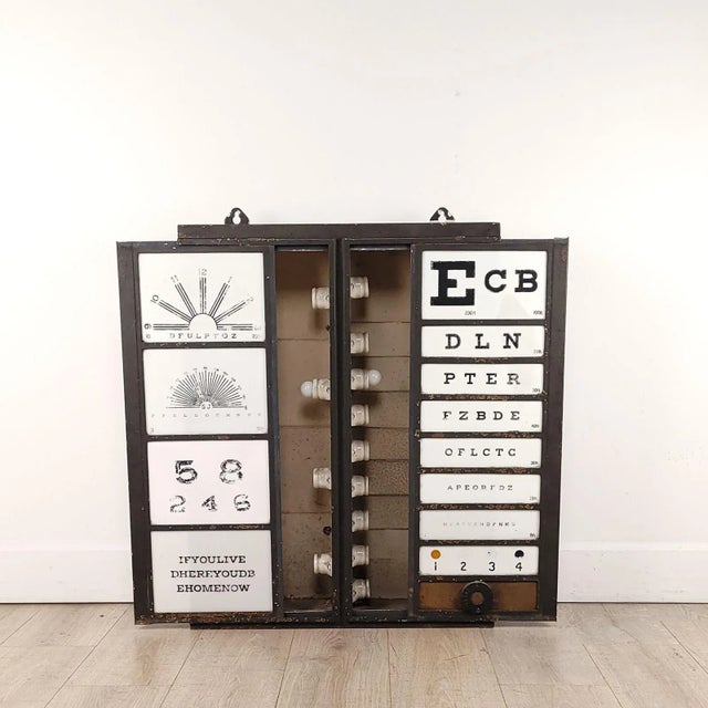 A vintage eye testing chart, backlit over painted glass, circa 1950. In need of rewiring.
