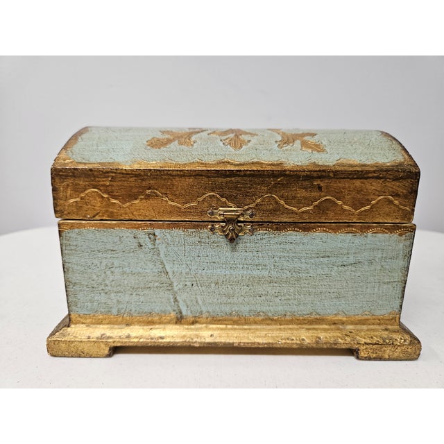This charming Italian trinket box is turquoise with gilt highlights and base. The interior of the box is 6.5 inches in...