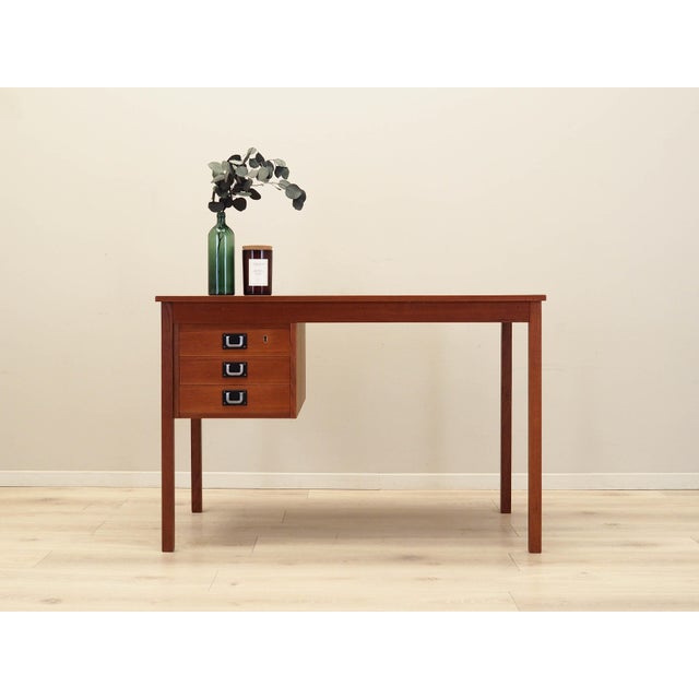 The desk was made in the 1970s, Danish production. The structure and tabletop are covered with teak veneer. The legs, made...