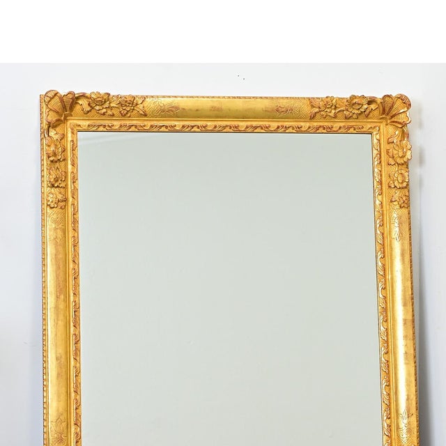 This French 19th century gilt mirror is symmetrical to hang in either direction, exhibiting high-relief floral decorations...