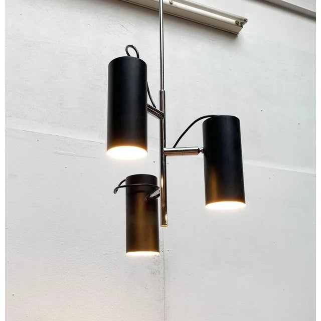 Mid Century rod pendant light with three spotlights. The design convinces with its minimalist form language. The luminaire...