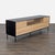 This media console features a sleek black top with natural wood drawers and cabinet doors. It offers plenty of storage...