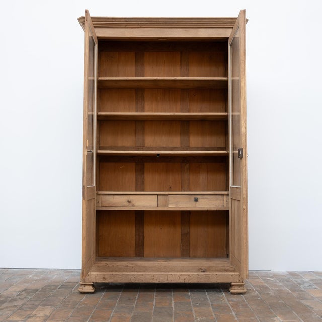 This imposing 19th-century glass-fronted bookcase is crafted primarily from oak. Its facade is punctuated by two large...