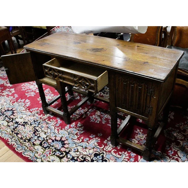 This antique English clerk's desk features beautifully carved oak construction, with a charming design and unique linen...