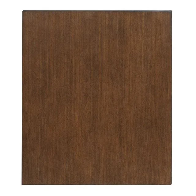 A rectangular top rests over two shelves elevated on a brass plated base. Crafted from hardwood solids and walnut veneer.