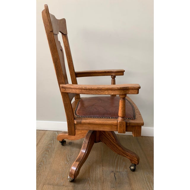 Antique oak swivel desk chair, likely dating from the early 20th century around 1900 to 1920. Crafted from solid oak with...