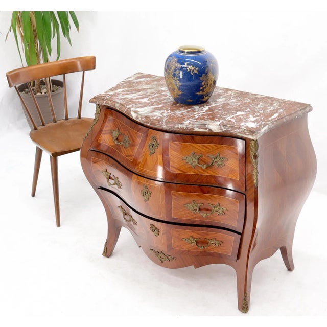 Stunning rouge marble-top French inlayed wood dresser with significant bronze ormolu. Very nice decorative piece.