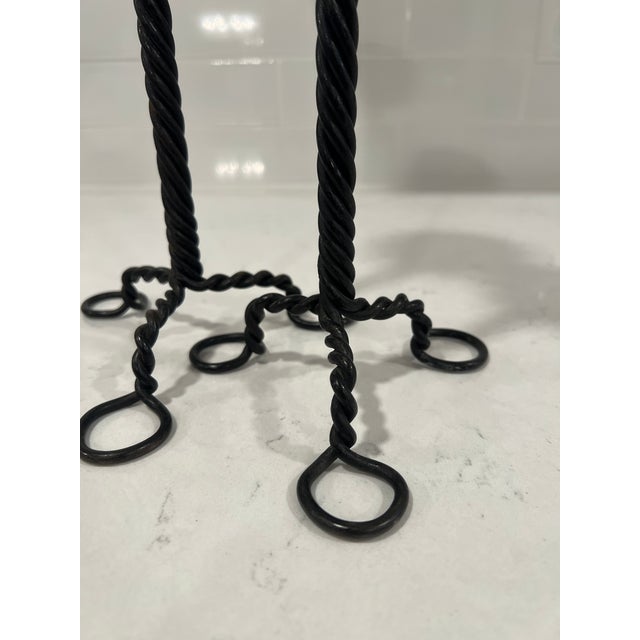 American, early 20th century. A two piece grouping of Arts & Crafts Period candlesticks. Each constructed with a twisted...