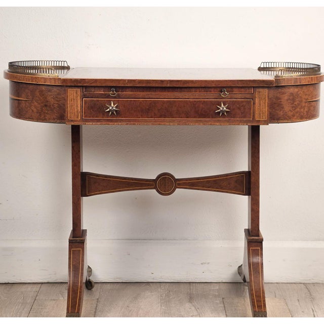 An early 19th-century English Regency-period game/writing table. Burled amboyna wood inlaid with satinwood ebony and...