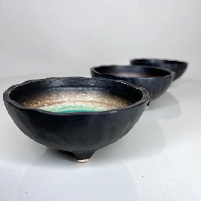 AMBIANIC presents 1960s Modern Japanese Small Enamel Bowl Set of Three Varied Colors Tripod Base Each dish has an enamel...