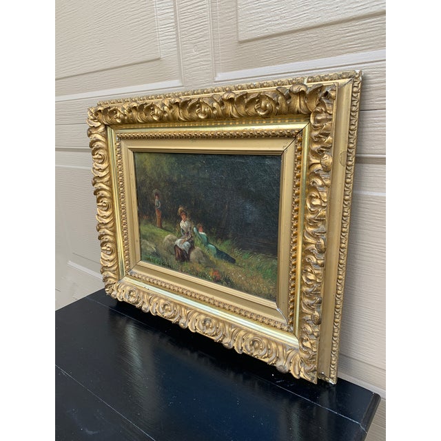 A beautiful antique hand-painted gilt wood framed oil on canvas landscape painting with three ladies lounging in the...