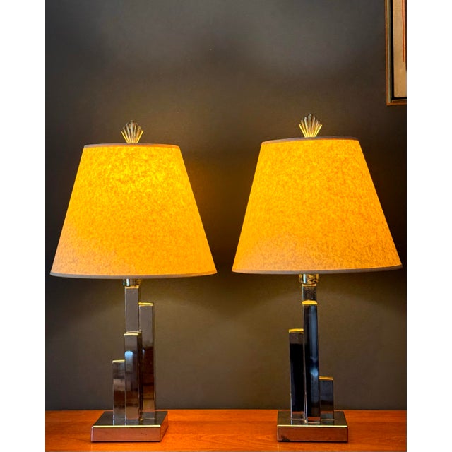 A sculptural pair of vintage chrome table lamps in a stepped, “skyscraper” form, likely dating to the late 20th century....