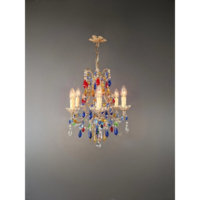 Florentine Gilded Iron Chandelier with Colored Crystals Italy, circa 1950 A striking Florentine chandelier from the...