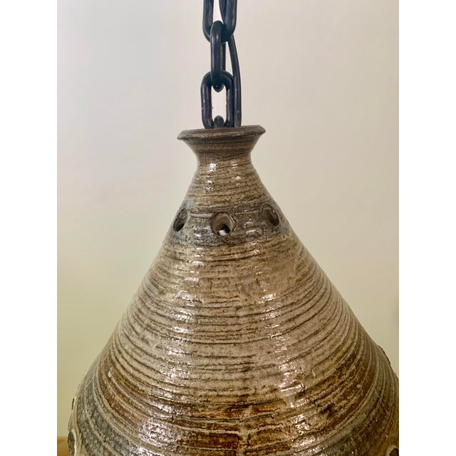 This charming pendant lamp features a textured ceramic shade with a pierced pattern , and dome shape, and a hanging chain....