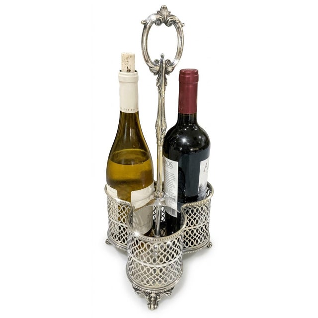 A beautifully crafted mid‑century silverplate triple wine bottle caddy featuring pierced gallery sides, decorative feet,...