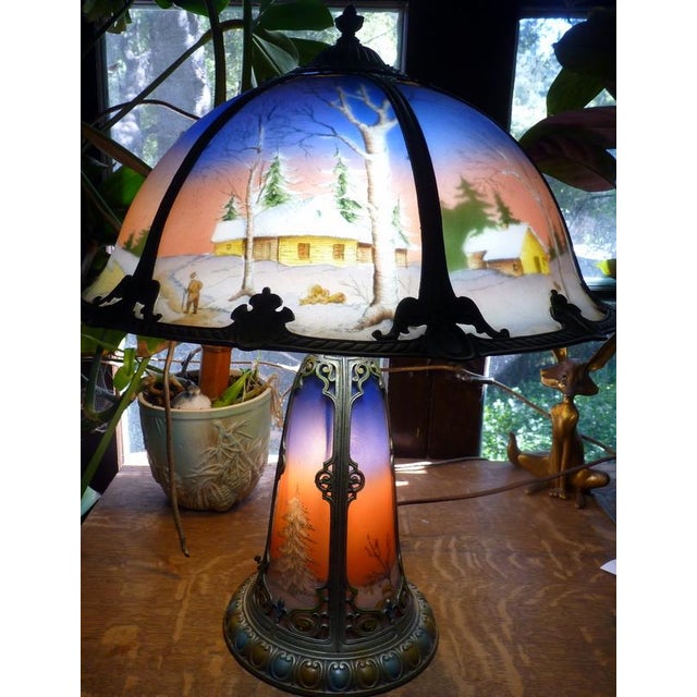 A striking and increasingly rare Miller Phoenix reverse-painted scenic table lamp, circa 1915–1920, featuring a richly...