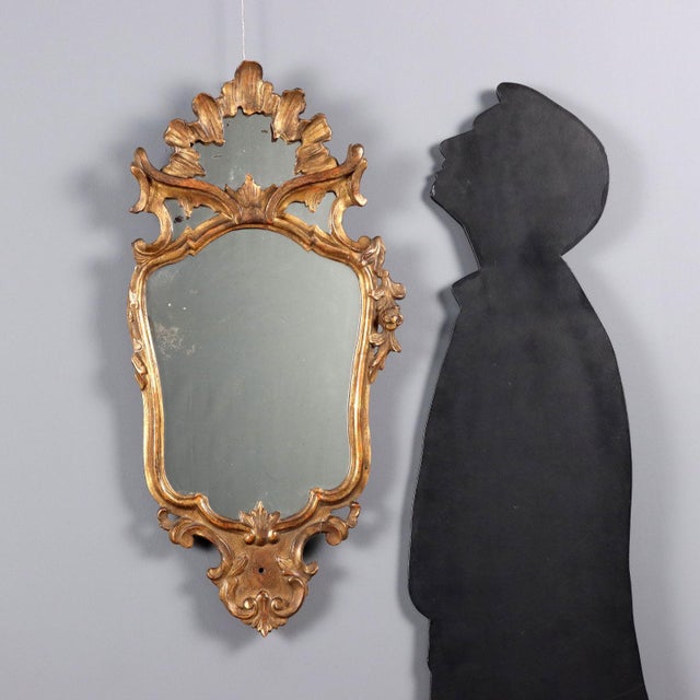 Small carved and gilded late Baroque mirror. Floral, leafy, and scroll carvings; the carving on the left side is missing....