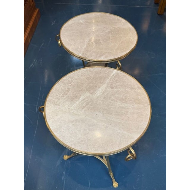 This product is a pair of vintage French Empire style gueridon tables, featuring a tabletop made of marble with a bronze...