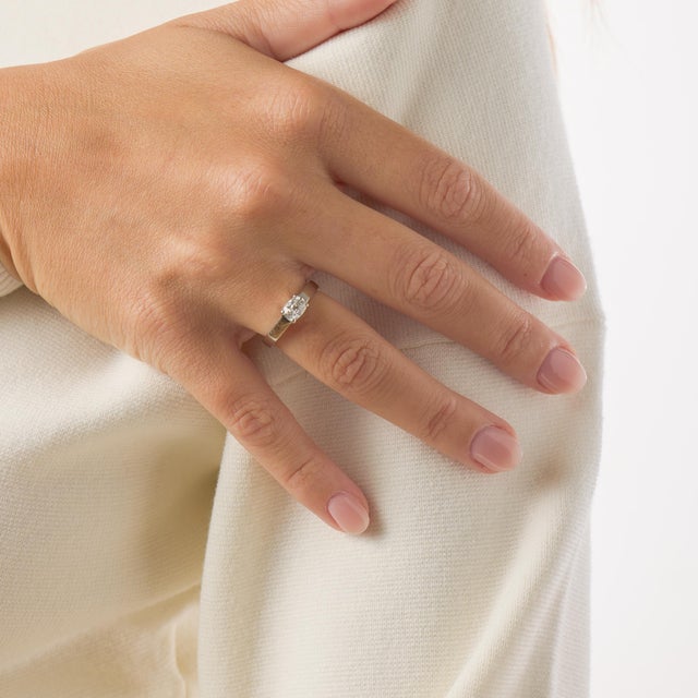 This elegant vintage engagement ring centers around a 0.80 carat old mine cut diamond, certified by GIA under report...
